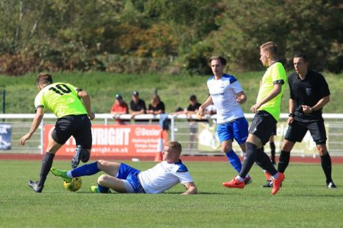 Referee Jonathan Creswick has a clear view as Enfields Sam Bantick trips Bradley Sach