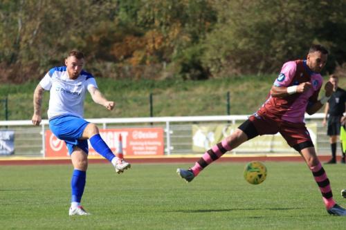 Billy Bricknell (L) scores the first Enfield goal past Mu Maans attempted block
