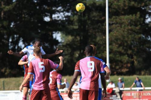 Enfields Ken Charles (white, L) heads just over