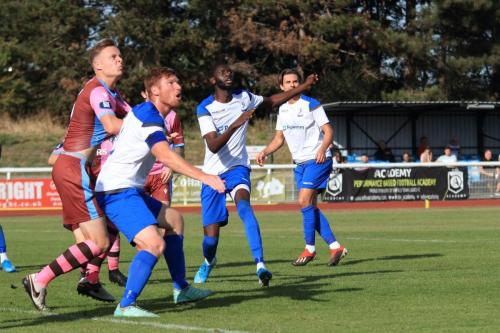 Enfields Marc Weatherston (white, L) and Muhammadu Faal and Casuals Jack Strange challenge for a long throw-in
