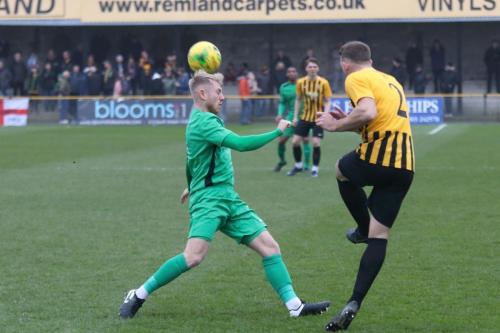 Folkestones Josh Vincent (R) clears from Ryan Blackman