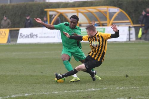 Folkestones Scott Heard (R) tackles Ken Charles