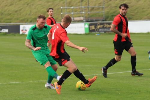 Enfields Billy Bricknell (L) shoots as Thomas Day tries to block