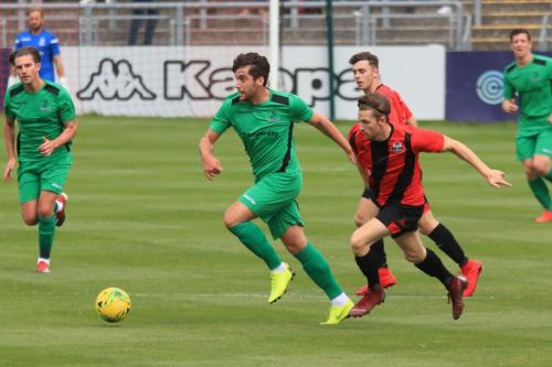Enfields James Potton (green) chased by Kieron Pamment
