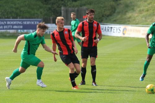 Enfields Lewis Taaffe (L) chases down a backpass from Thomas Day (centre)