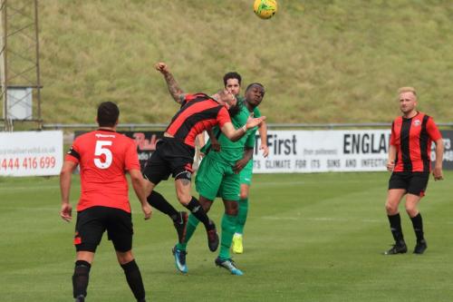 Lewes Stacey Freeman heads clear from Ken Charles (green)