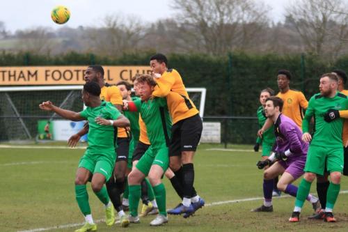 Mesthams EJ Mensah (amber, 2nd L) heads clear from Enfield captain Marc Weatherstone