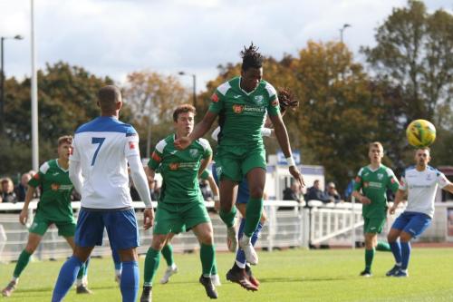 Leatherhead's Crossley Lima heads clear from an Enfield long throw