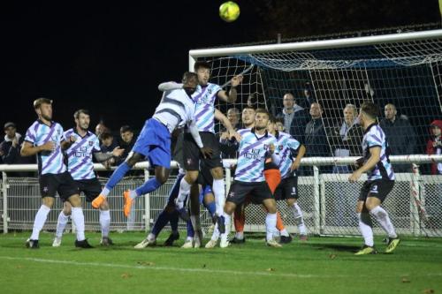 Enfield's Adam Pepera (white shirt) challenges Liam Friend