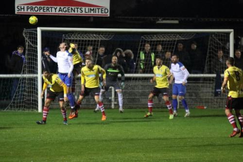 Enfield's Sam Youngs (white, L) flicks the ball on at a corner