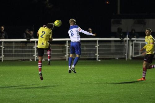Kingstonian's Harry Osborne (L) heads clear from Ryan Blackman