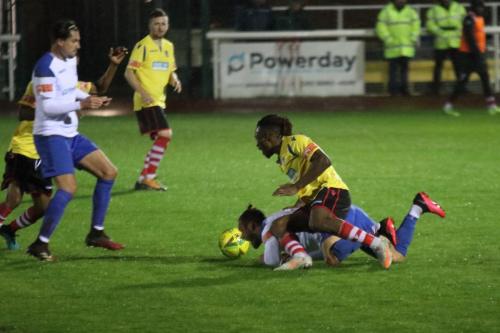 Kingstonian's Kadell Daniel (yellow, R) challenges Scott Thomas