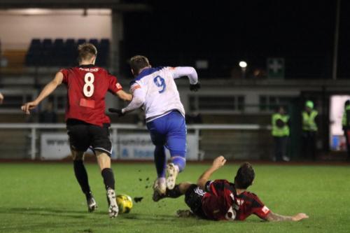 Brightlingsea's Pip Boyland (R) trips Billy Bricknell
