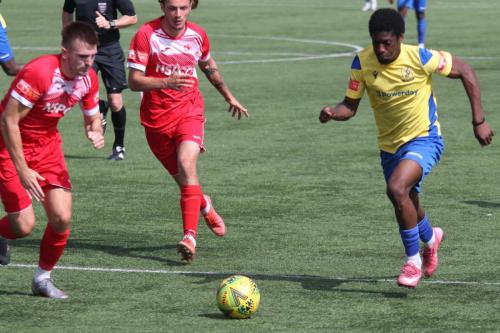 Enfield's Andre Coker (R) runs at the Carshalton defence