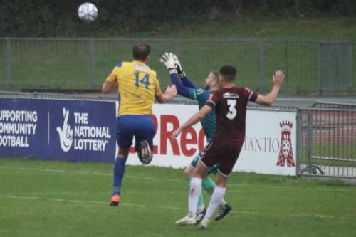 IMG 5210-Enfields-Adam-Cunnington-challenges-keeper-Jacob-Marsden.-The-resulting-collision-saw-both-players-need-treatment.