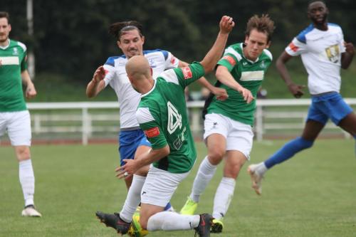 Dereham's Andrew Fisk (4) challenges Sam Youngs