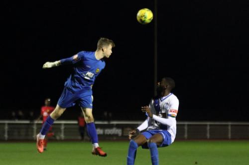 IMG 8044-Merstham-keeper-Toby-Bull-heads-clear-from-Muhammadu-Faal-who-retrieves-the-ball-and-sets-up-Andre-Coker-for-the-third-Enfield-goal