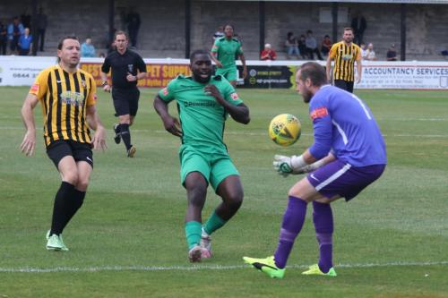Folkestone keeper Tim Roberts collects ahead of Percy Kiangebeni