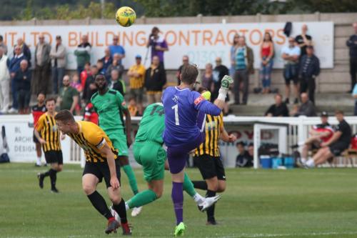 Folkestone keeper Tim Roberts clears from Adam Cunnington