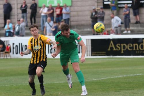 Adam Cunnington (R) wins a header