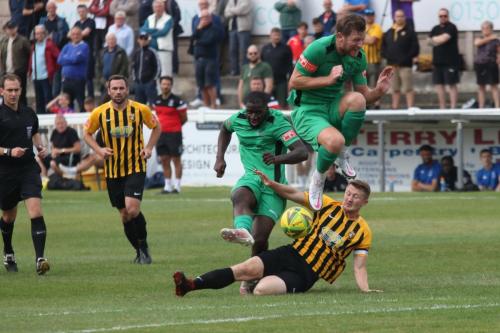 Enfield's Percy Kiangebeni shoots as Callum Davies tries to block and Adam Cunnington jumps out of the way