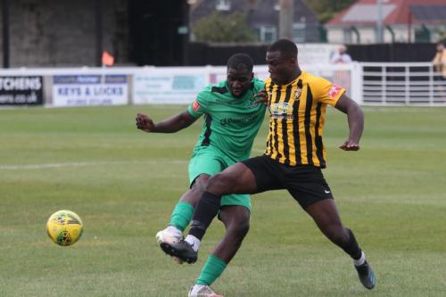 Folkestone's Adam Yusuff (L) clears just as Percy Kiangebeni shoots