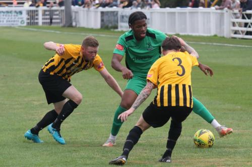 Folkestone's Scott Heard (L) and Jordan Wright challenge Manny Maja