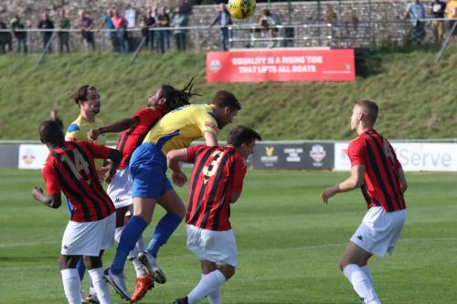 IMG 4243-Lewes-Bradley-Pritchard-red-beats-Adam-Cunnington-to-the-ball-but-can-only-deflect-it-to-Muhammadu-who-scores-Enfields-goal