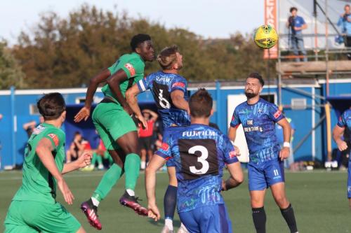 IMG 4934-Enfields-Jerry-Gyebi-green-R-wins-a-header-against-Ben-Swift