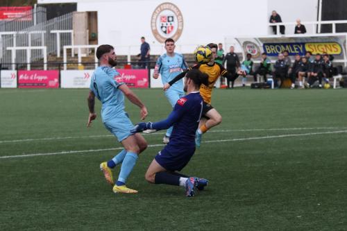 IMG 9913-Jake-Cass-lifts-the-ball-over-Shaun-Rowley-but-Kellen-Fisher-R-is-able-to-get-back-to-clear