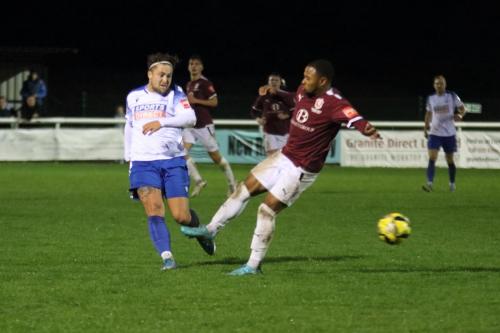 IMG 0838-Lewis-Taaffe-takes-aim-at-the-empty-net-past-the-challenge-of-Knory-Scott-but-the-ball-rolls-narrowly-wide