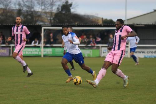 IMG 5970-Manny-Parry-plays-the-ball-back-to-his-goalkeeper-as-Reece-Beckles-Richards-closes