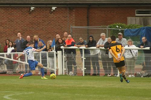 Enfield's Ryan Kirwan crosses with Cheshunt's Tom Gardiner in pursuit